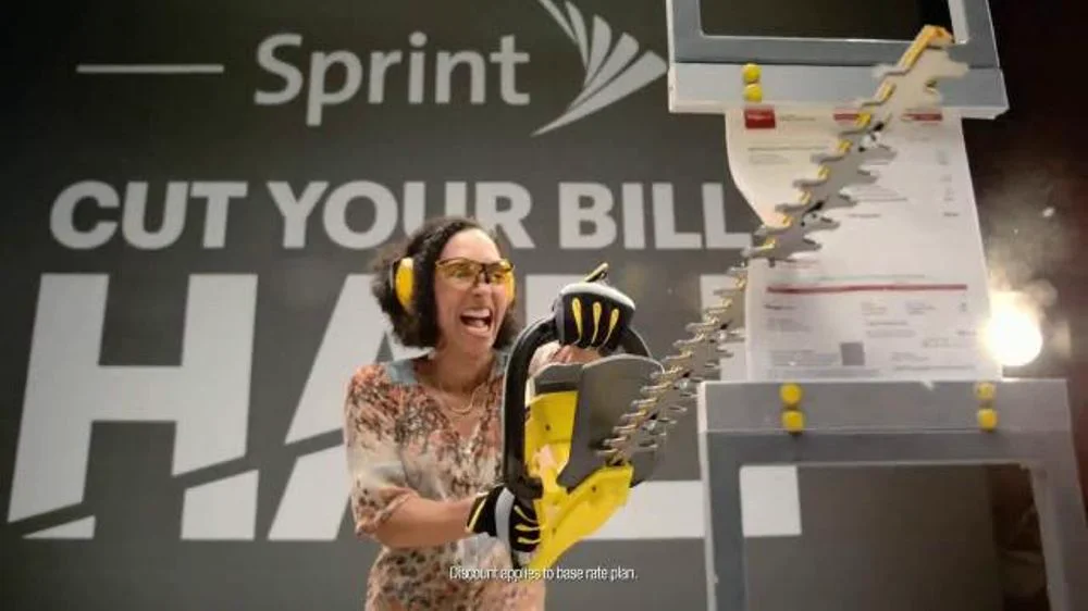 Sprint campaign themed display with hedge trimmer cutting a large phone bill prop